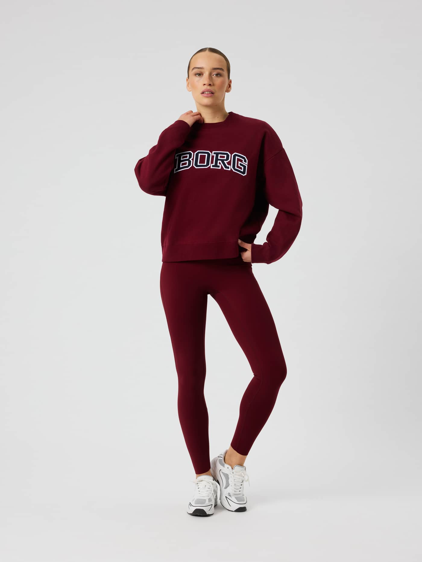Front view of a model wearing the Borg Boyfriend Sweatshirt in Cabernet (Red) featuring a white and dark blue logo. - Image 4