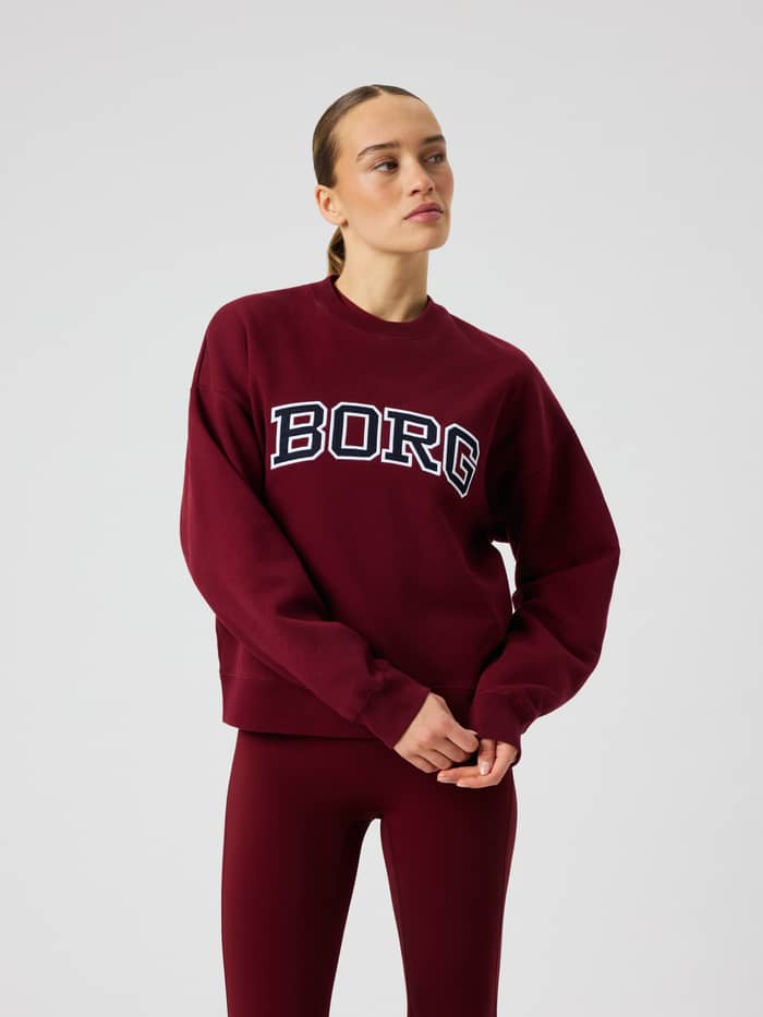 Front view of the Borg Boyfriend Sweatshirt in Cabernet (Red) featuring a large white and dark blue logo print on the chest.