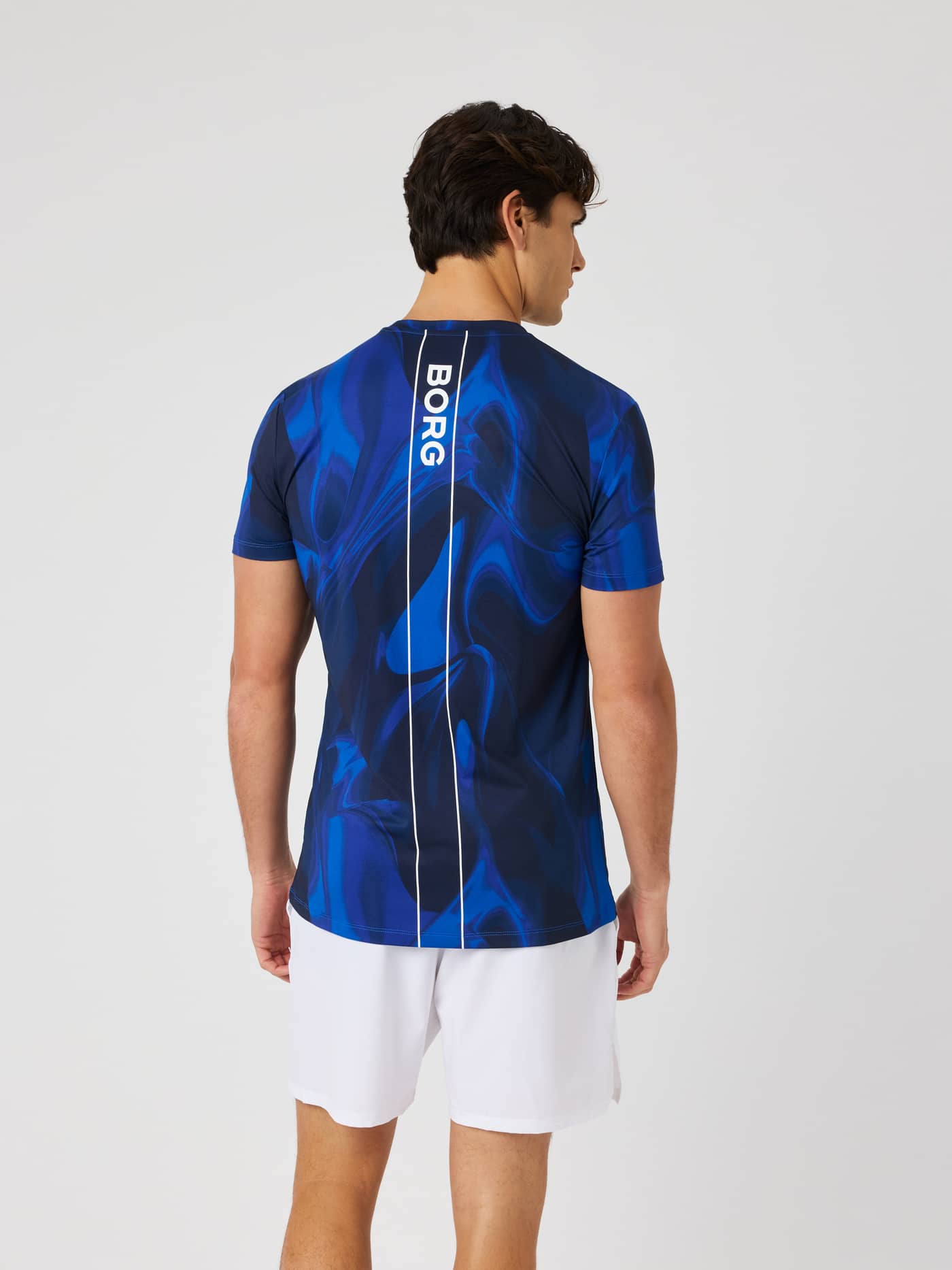 Back view of the Ace Printed T-Shirt in blue wave pattern, featuring a white back stripe and BORG logo for tennis. - Image 2