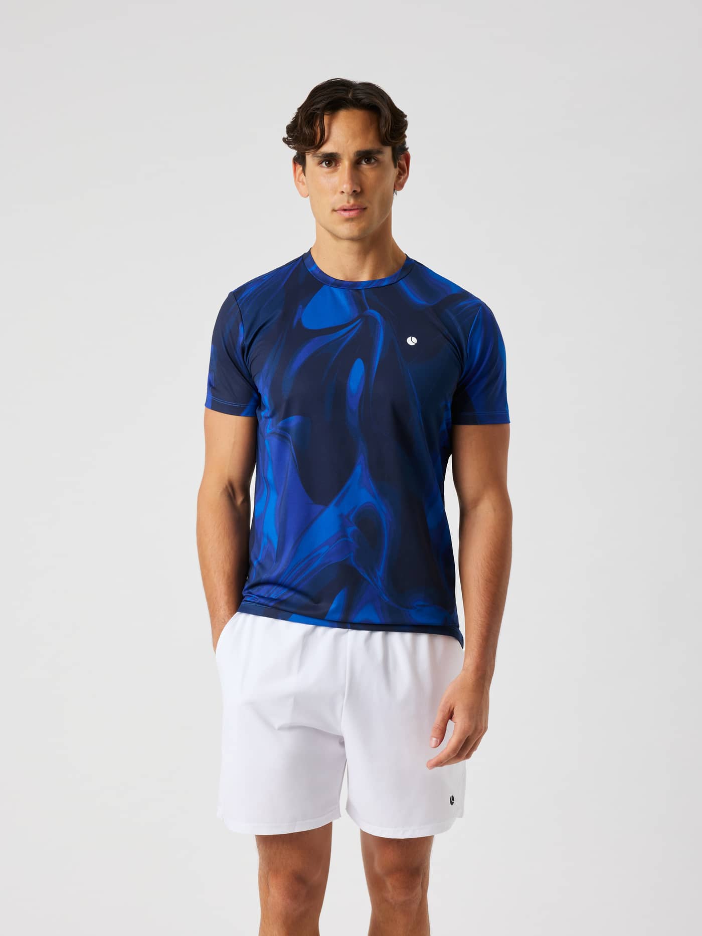 Man wearing the Ace Printed T-Shirt in blue and dark blue wave print, featuring a white logo for tennis. - Image 1