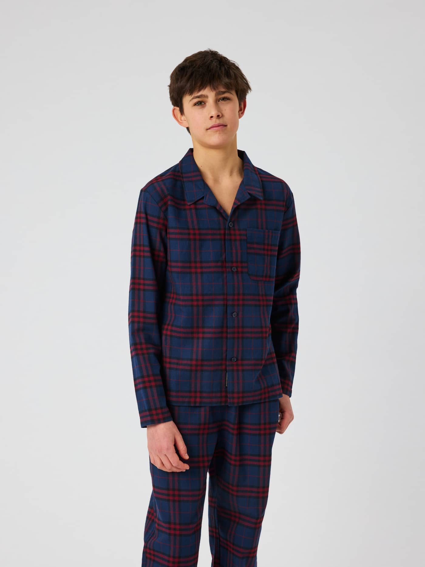Front view of a kid wearing the checked Core Flannel Pyjama Set 2-pack in multi colors. - Image 2