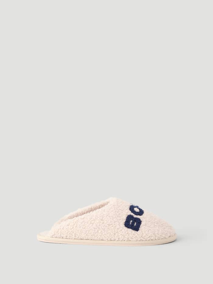 Side view of the Haven Slipper in Tofu and Peacoat, featuring soft polyester pile and navy Borg branding on the vamp.