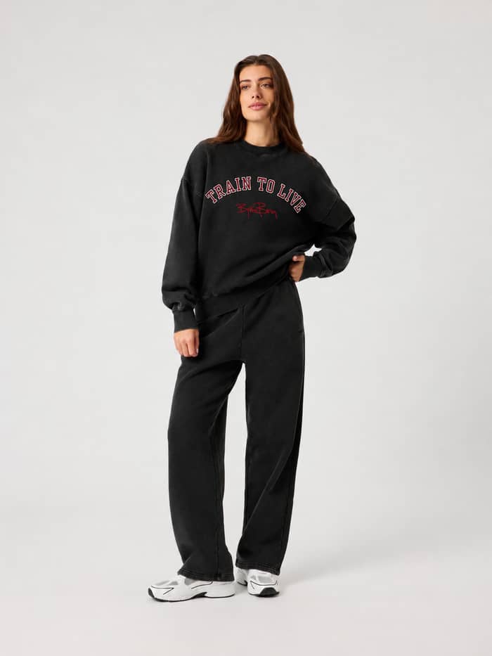 Studio Oversized Sweatshirt in Washed Out Black (zwart) met relaxed fit, ronde hals en training-details, gedragen door vrouw.