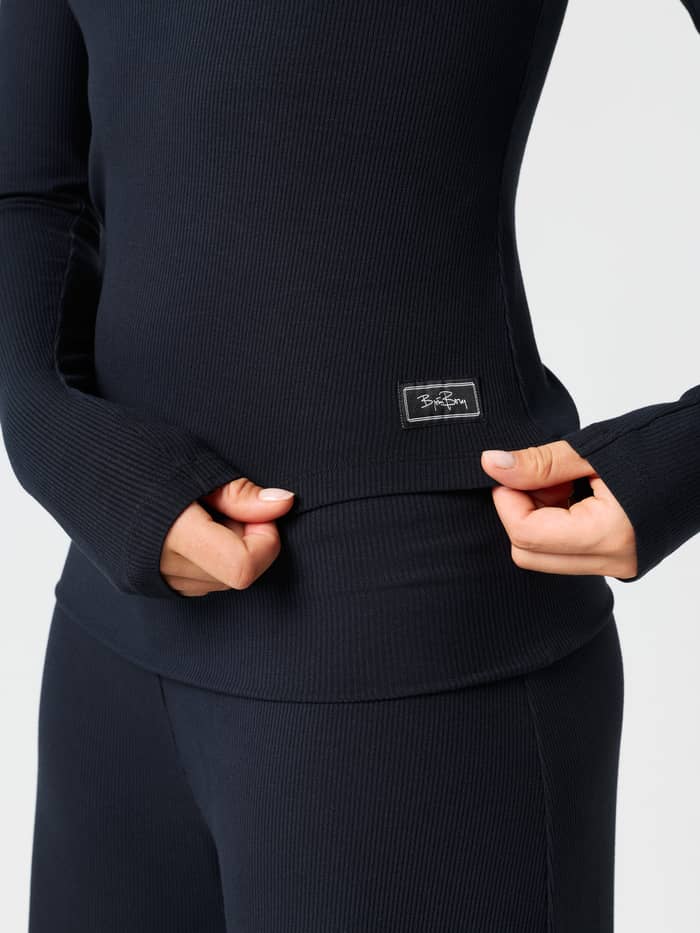 Close-up of the Studio Rib Long Sleeve in Black Beauty (Black), highlighting the ribbed texture and logo label.