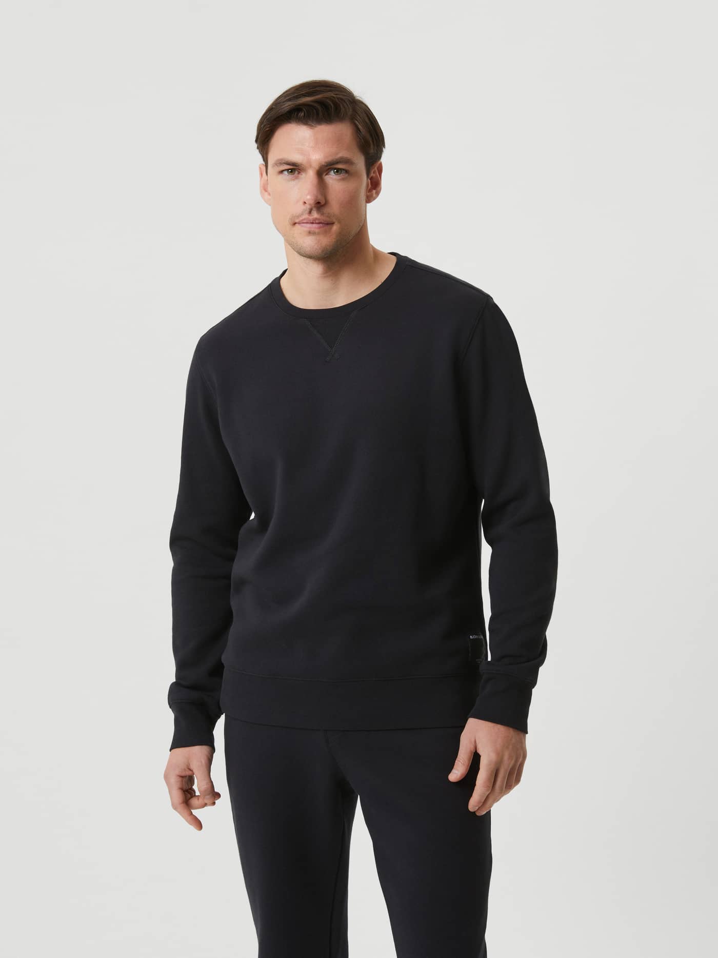 Vooraanzicht van een man in de Björn Borg Centre Crew in Black Beauty (Zwart), een stijlvolle katoenmix sweater. - Image 2