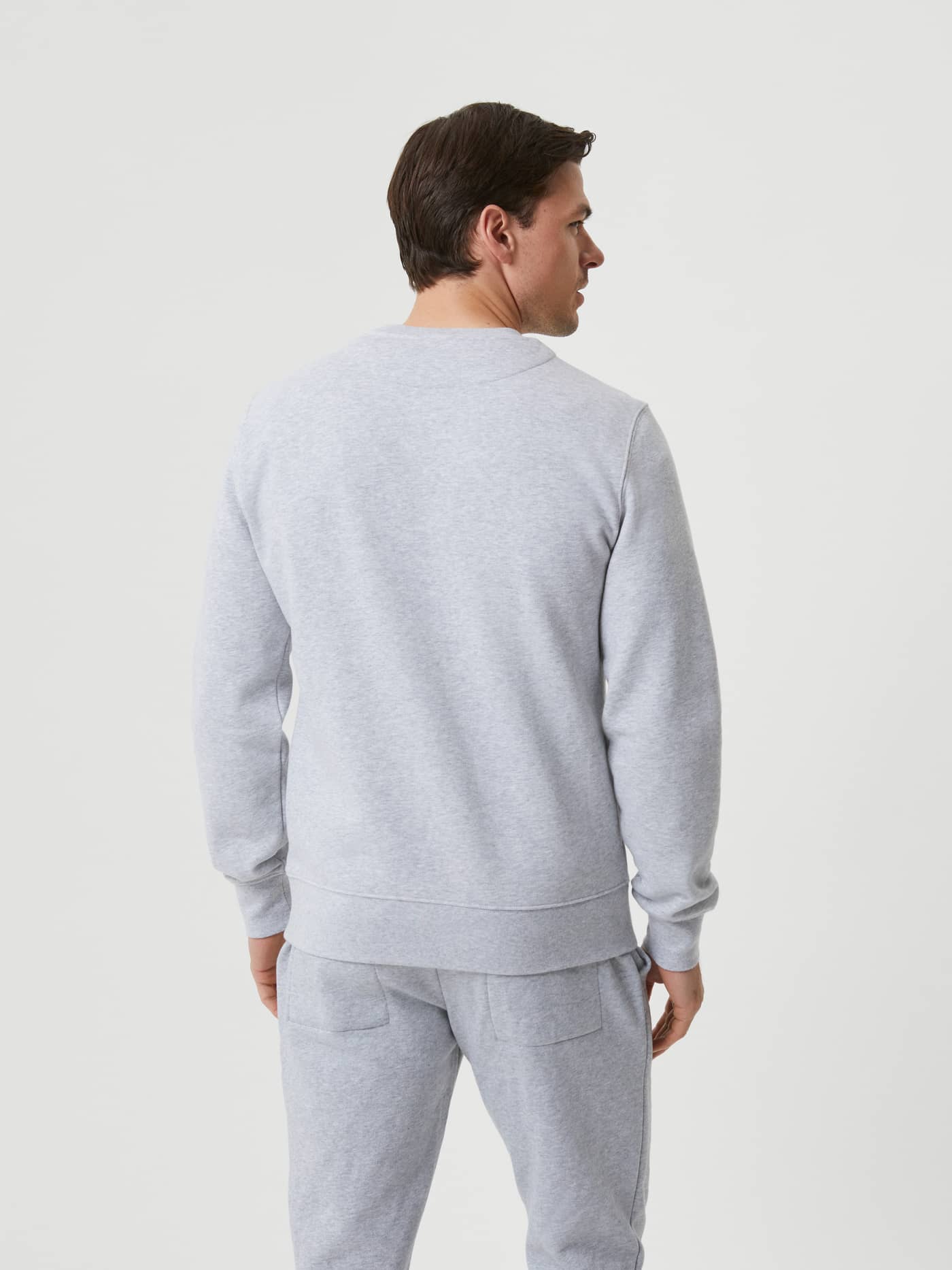Back view of a man wearing the Björn Borg Centre Crew in Light Grey Melange (Grey), a stylish and functional cotton sweater. - Image 3