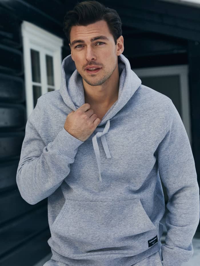 Front view of a man wearing the Björn Borg Centre Hoodie in light grey melange, featuring a comfortable regular fit. - Image 5