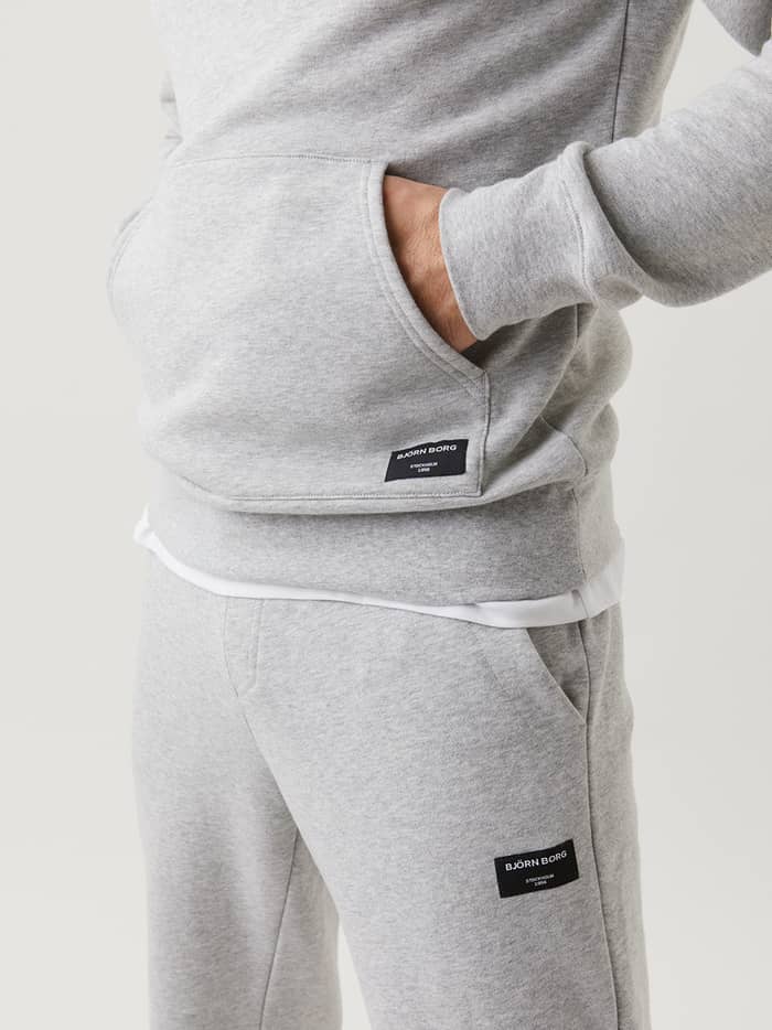 Björn Borg Centre Hoodie in Light Grey Melange (Grey) shown in a close-up featuring a kangaroo pocket and black logo label. - Image 4