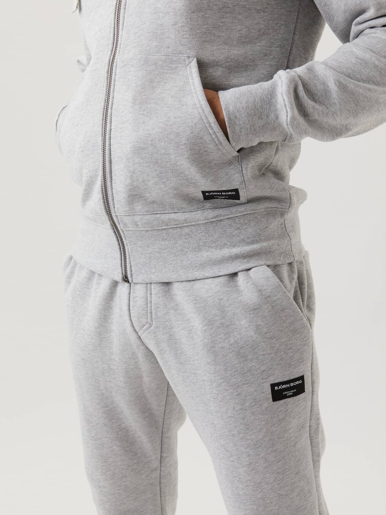 Close-up of the Björn Borg Centre Zip Hood in Light Grey Melange (Grey) showing its functional pockets and stylish fit. - Image 2