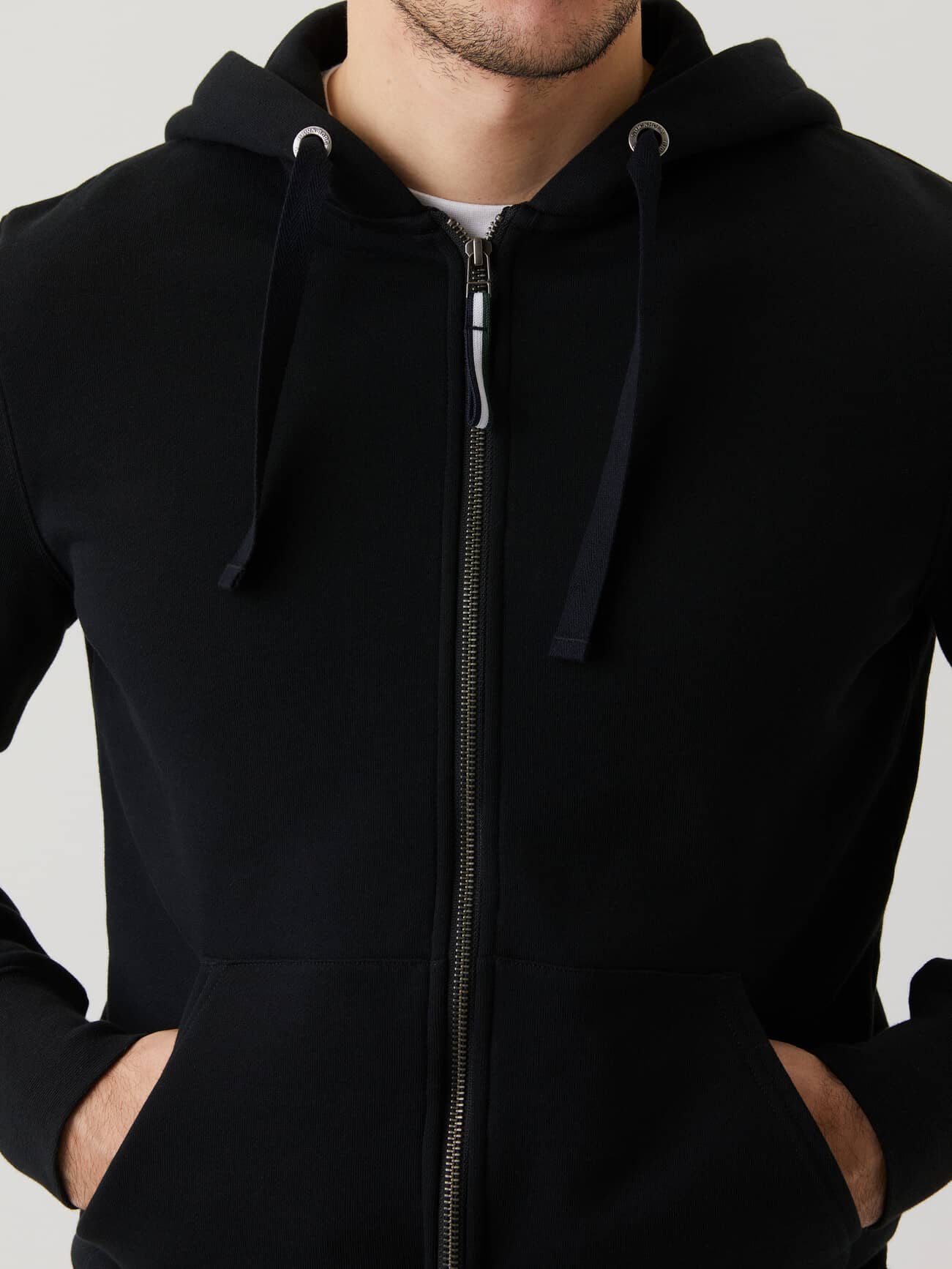 Front view of a man wearing the Björn Borg Centre Zip Hood in Black Beauty (Black), highlighting the stylish metal zipper. - Image 2