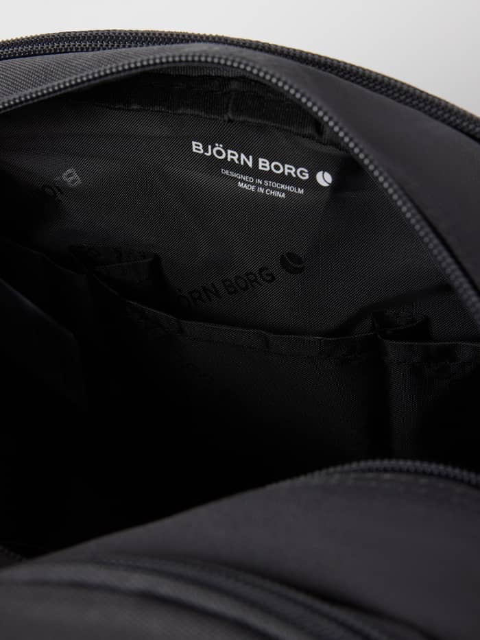 Interieur van de Core Wash Bag Standing in Asphalt (Grijs) met het witte logo en handige binnenvakken. - Image 4
