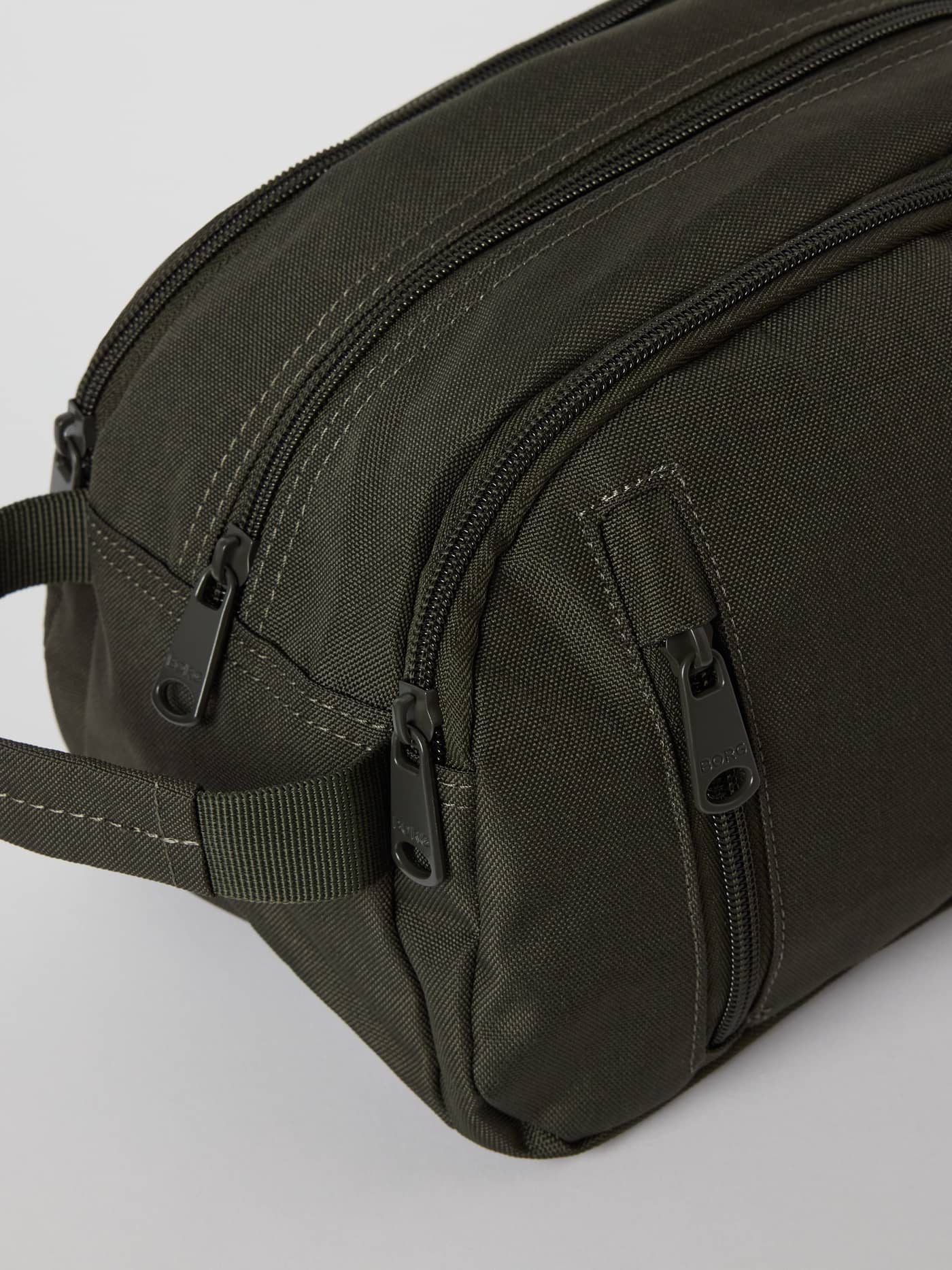 Close-up of the Björn Borg Core Wash Bag Standing in Forest Night (Green) featuring recycled polyester and zip closures. - Image 3