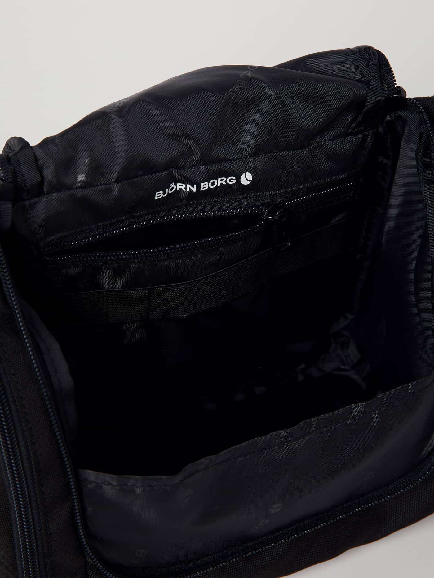 Binnenaanzicht van de Core Toilet Case Hanging in Black Beauty (Zwart) met een wit logo en ritsvak. - Image 4