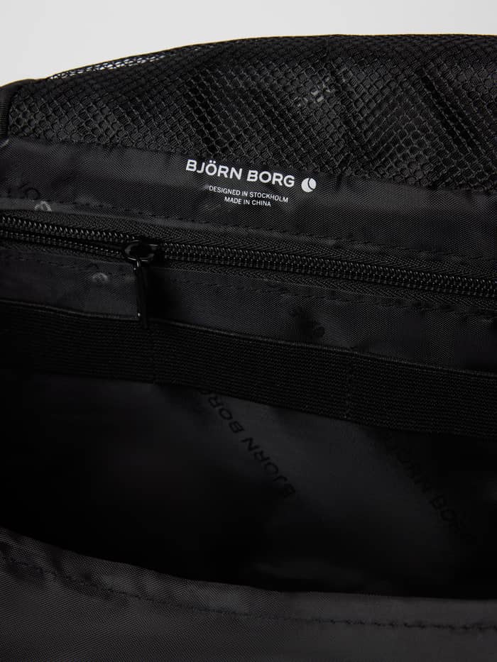 Gedetailleerd binnenaanzicht van de Core Wash Bag Hanging in Asphalt (Grijs) met een mesh vak en wit logo. - Image 4