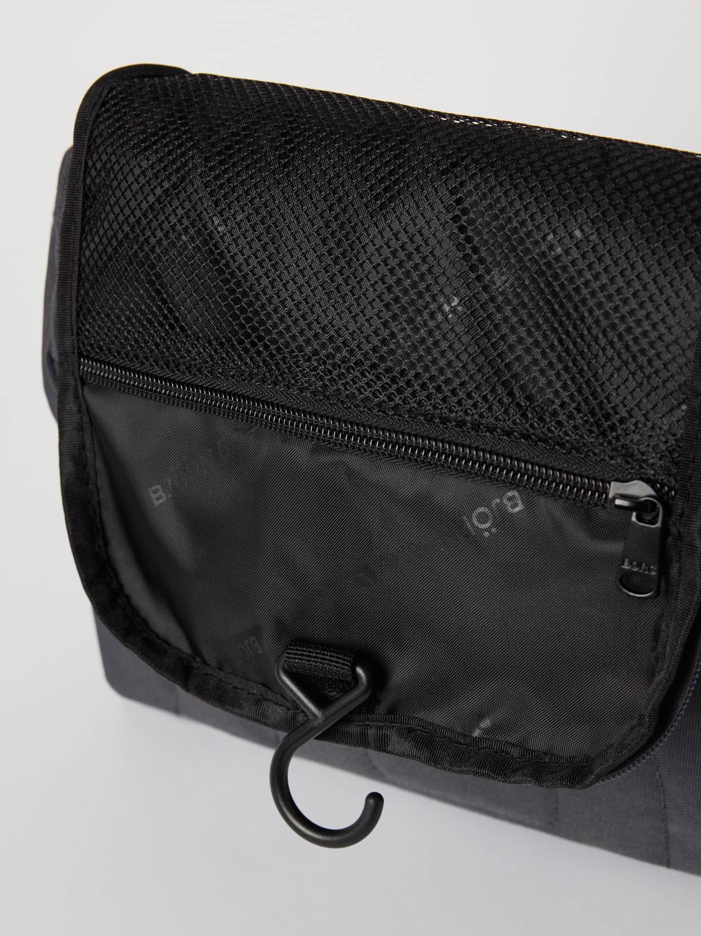 Interior view of the Asphalt (Grey) Core Wash Bag Hanging, featuring the mesh pocket and integrated hanging hook. - Image 2